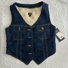 Super Cute Vest For A Festival Fit. I’ve Worn It Once And I Absolutely Loved It But Was A Bit Tight Around The Chest! Winter Cotton Denim Top With Pockets, Winter Denim Top With Pockets In Medium Wash, Dark Wash Denim Top For Winter, Winter Dark Wash Denim Top, Winter Dark Wash Cotton Denim Vest, Casual Denim Blue Vest For Winter, Winter Blue Denim Top With Pockets, Winter Medium Wash Denim Top, Casual Dark Wash Denim Vest For Winter