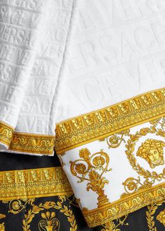 two white and gold bedspreads are laying next to each other