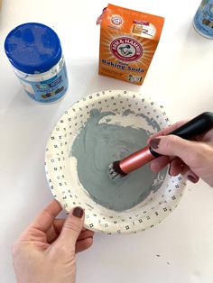 someone is painting a bowl with gray paint