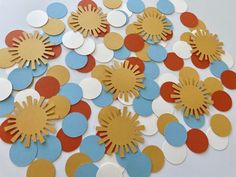 the sun is surrounded by many different colored circles on white paper with red, blue, and yellow dots