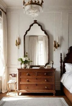 a bedroom with a bed, dresser and large mirror in front of the window on the wall