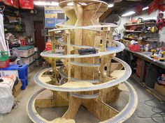 a large wooden structure made out of plywood and wire in a shop with tools on the floor