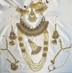 *Adorn yourself with this stunning gold polki jewelry set with pearls for your special day!  *Made with high quality craftsmanship  *10-piece set includes the following: - 1 Large chocker necklace - 1 Long Pearl necklace - 1 Passa - 1 Tikka - 1 Matha patti - 2 Earrings with hair attachment - 2 Hath paan (ring with attached bracelet - 1 Nose ring with chain Gold Bridal Sets With Stone Work For Celebration, Gold Bridal Sets With Meenakari For Reception, Gold Temple Jewelry For Wedding Reception, Traditional Gold Chandbali With Stone Work For Wedding, Gold Bridal Sets With Zari Work For Reception, Gold Kundan Bridal Set Hand Set, Kundan Jewelry Sets In Yellow Gold For Wedding, Wedding Kundan Jewelry Sets In Yellow Gold, Kundan Yellow Gold Jewelry Sets For Wedding