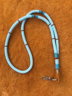 a blue and brown leash on a tan surface