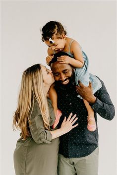 a man and woman holding a child in their arms