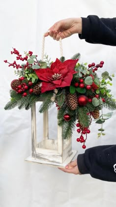 a person is holding a christmas decoration in their hand and pulling it from the box