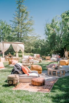 a man laying on top of a couch in the middle of a field with lots of furniture