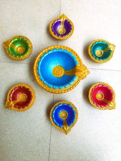 five colorful plates with gold trim on the floor