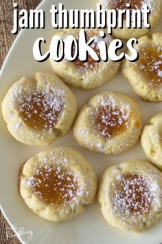 jam thumbprint cookies on a white plate with powdered sugar and text overlay