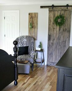 a living room filled with furniture and a wooden door leading to another room that has been decorated in black and white