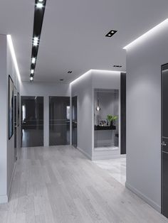 an empty room with white walls and wood flooring is lit by recessed lights