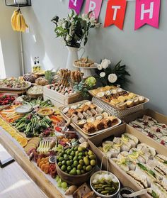 a table filled with lots of food and bunting flags hanging from the wall above it