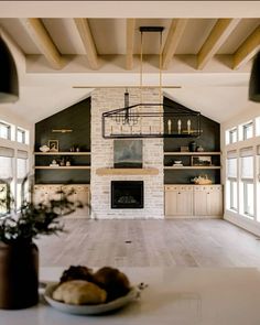 a large open living room with white walls and wood beams on the ceiling is filled with furniture