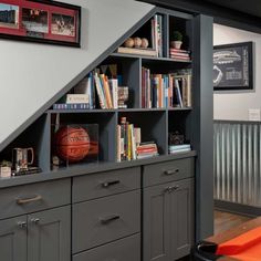 a bookshelf with basketballs and other sports memorabilia on it in a home office