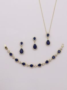 "Add a touch of sparkle and these classically designed framed blue sapphire colored cubic zirconia teardrop wedding earrings, necklace and bracelet set that dangle with sparkle. Measuring 1 1/4\" long, these are perfect for any special occasion. Necklace measures 16\"-18\" (adjustable). Optional bracelet measures 7\" long. Choose from silver, gold or rose gold. All jewelry features high quality electroplating that does not fade or chip and is nickel free (hypoallergenic). Orders are shipped via Gold And Blue Bracelet, Blue Sparkling Stones Jewelry For Wedding, Sapphire Cubic Zirconia Jewelry For Wedding, Sapphire Jewelry With Sparkling Stones For Wedding, Sapphire Cubic Zirconia Wedding Jewelry, Elegant Sapphire Drop Jewelry, Sapphire Cubic Zirconia Dangle Jewelry, Blue Gold-plated Jewelry With Matching Earrings, Blue Teardrop Jewelry Sets For Formal Occasions