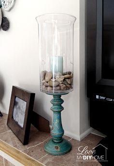 a glass vase filled with rocks on top of a table next to a framed photo