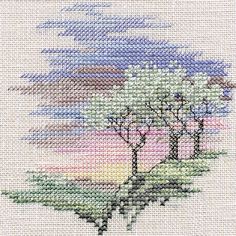 a cross stitch pattern with trees and clouds in the background