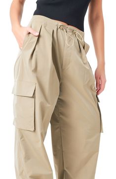 Rock a laid-back look in baggy, low-rise parachute pants equipped with a pleated toggle waist, cargo pockets and snaps to adjust the cuffs. Zip fly; drawcord-toggle waist Side slant pockets; side cargo pockets 55% nylon, 45% polyester Hand wash, dry flat Imported Spring Utility Parachute Pants In Khaki, Utility Parachute Pants With Belt Loops For Spring, Spring Khaki Parachute Pants With Cargo Pockets, Relaxed Fit Khaki Parachute Pants With Belt Loops, Spring Utility Parachute Pants With Flap Pockets, Khaki Relaxed Fit Parachute Pants With Belt Loops, Spring Outdoor Cargo Pants With Belt Loops, Nylon Cargo Parachute Pants For Work, Spring Cargo Pants With Belt Loops For Outdoor