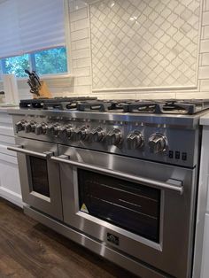 a silver stove top oven sitting inside of a kitchen