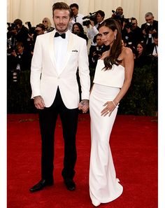 a man in a tuxedo standing next to a woman in a white dress