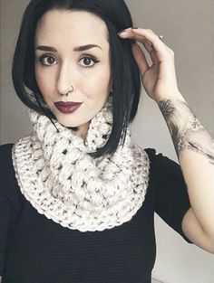 a woman with black hair wearing a white crochet scarf