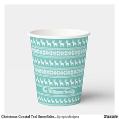 a green and white christmas themed cup with reindeers on the front, and snowflakes on the back