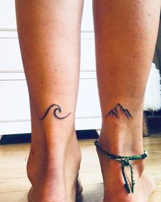 two people with tattoos on their feet and one has a mountain tattoo on the ankle