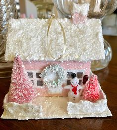 a small house made out of paper and decorated with snowmen, christmas trees and decorations