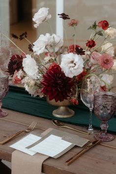 the table is set with flowers and silverware