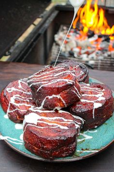 some food is sitting on a plate by the fire