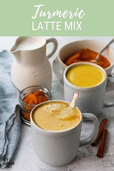 three mugs filled with different types of food on top of a white tablecloth