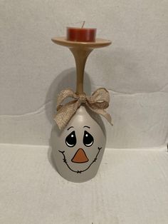 a ceramic bird with a bow on it's head sitting next to a candle holder