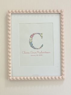 a white frame with a flowered initial on it