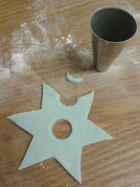 a wooden table topped with a metal cup and star cut out