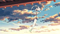 a wind chime hanging from the ceiling with clouds in the background