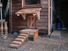 an outside view of a wooden building with steps leading up to the door and window