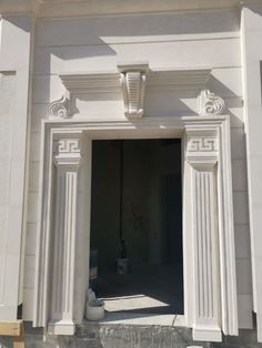 an entrance to a white building with columns