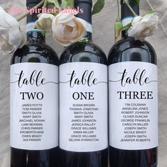 three wine bottles with names and flowers on them