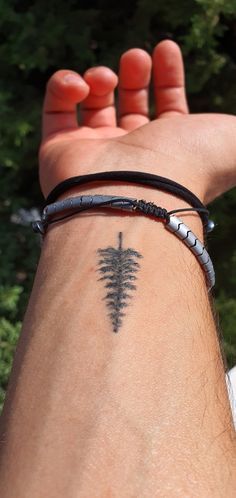 a man's arm with a tattoo on it and a tree design on the wrist