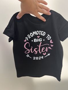 Celebrate a special promotion with our "Promoted to Big Sister" shirt! Made from soft 100% cotton jersey, this cozy unisex infant shirt ensures comfort and style.  Features include: - 5.5 oz. fabric weight - Ribbed collar and double-needle sleeves/bottom hem for durability - Machine washable and tumble dry low This shirt is a cherished keepsake for your little one's big announcement. Cotton Birthday Shirt With Slogan, Cotton Slogan Shirt For Birthday, Birthday Cotton Slogan Shirt, Black Letter Print Shirt For Gender Reveal, Black Crew Neck Top For Gender Reveal, Black Top With Name Print For Gender Reveal, Black Short Sleeve Tops For Gender Reveal, Basic Cotton Top, Sister Announcement