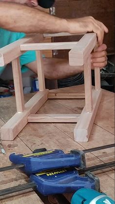 a man is working on some wooden furniture