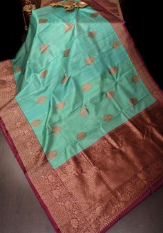 This Pure Tussar Silk Banarasi Saree in greenish cyan is a sublime fusion of tradition and sophistication. The saree, crafted from luxurious tussar silk, showcases the intricate antique zari kadhuwa weaving, renowned for its rich texture and timeless beauty. The greenish cyan hue provides a refreshing and unique twist, setting it apart with a vibrant yet elegant tone. The antique zari work, with its golden shimmer, is meticulously woven into the fabric, creating a stunning visual contrast and enhancing the saree's opulent appeal. Ideal for festive occasions and grand celebrations, this saree embodies regal charm with a modern touch, promising to make a memorable impression with its exquisite craftsmanship and striking color. SILK MARK CERTIFIED This saree is ready to wear with fall and pic Luxury Tussar Silk Sets For Women, Luxury Green Tussar Silk Sets, Luxury Festive Tussar Silk Set, Luxury Silk Fabric With Zari Weaving, Luxury Traditional Zari Weaving Fabric, Elegant Luxury Sets With Zari Weaving, Luxury Tussar Silk Saree With Zari Weaving, Luxury Tussar Silk Traditional Wear With Zari Weaving, Luxury Banarasi Silk Fabric With Zari Weaving