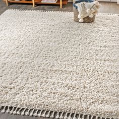 a white rug with fringes on the floor in a living room