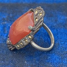 Fabulous ~ Vintage Art Deco ~ silver tone ~ open-back , prong set , carnelian glass ~ cocktail /dinner Ring ~ Unsigned Dates early 20th century ~ unmarked but most likely Czech or German in origin . Materials : Silver tone metal /pot metal glass marcasite beads Measurements : Ring can fit size 5 - 5 1/2 Top measures 1 1/4 inches x 3/4 inches max width ~ Stone itself is 3/4 inches x 1/2 inches wide Condition : Good vintage condition with heavy age patina to metal ~ no cracks or chips to the glass Dinner Ring, Cocktail Dinner, Art Deco Silver, Vintage Cocktail Ring, Glass Ring, Ring Art Deco, Vintage Cocktail, Glass Rings, Deco Jewelry