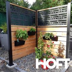 a wooden fence with potted plants on it and the word hot in front of it