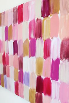 an abstract painting with many different shades of pink, yellow and red on the wall