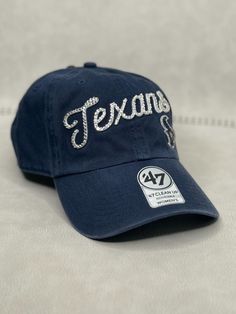 This is a navy blue HOU Texans script 47 clean up adjustable hat that is hand embellished with varying sizes of transparent red, blue and silver Swarovski style crystals on the front cursive and small logo .  This hat features over 250+ varying size Swarovski style crystals.  - 100% Cotton - Matching fabric strap & buckle  - One Size Fits All - Raised Embroidered Logo - 250+ Swarovski style transparent red, blue and silver crystals individually placed by hand - Ready to ship in 1 week from San D Rhinestone Football, Bling Hat, Sports Hat, Fabric Strap, Sport Hat, Womens Football, Adjustable Hat, Trucker Cap, Blue And Silver