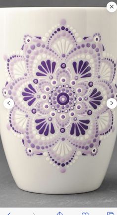 a white cup with purple designs on it