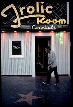 a man walking in front of a building with a star on the sidewalk next to it