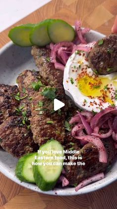 a bowl filled with meat and vegetables on top of a wooden table